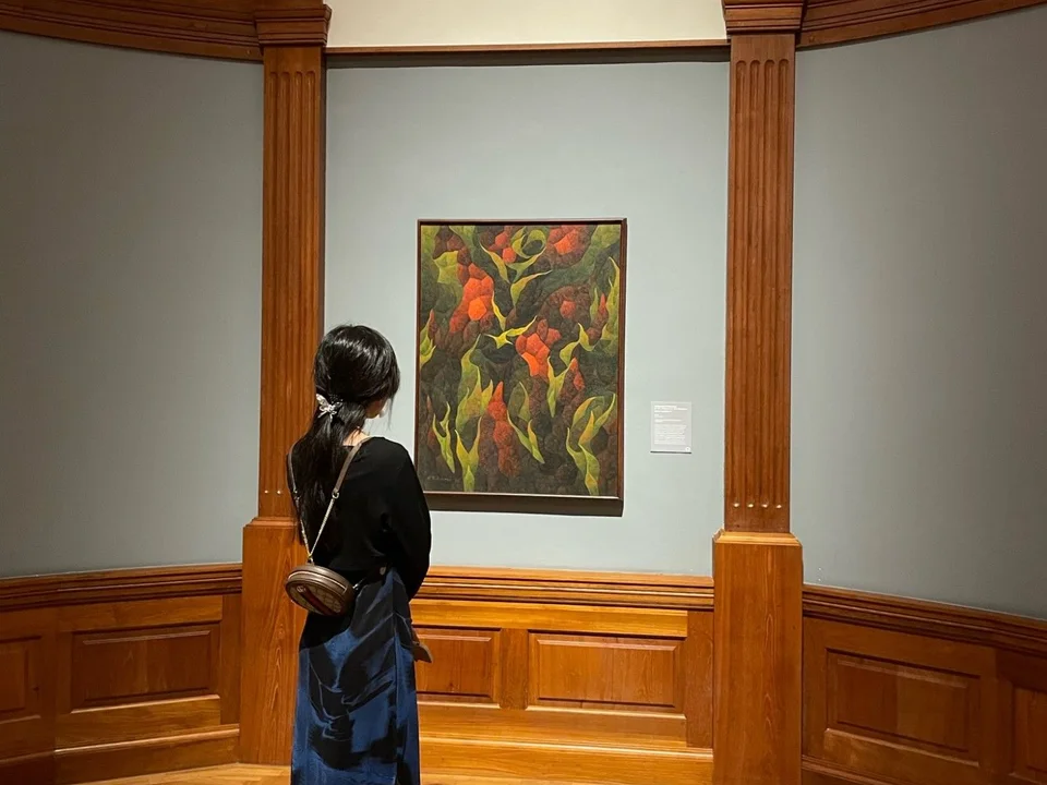 Looking at a painting in a wood-panelled gallery