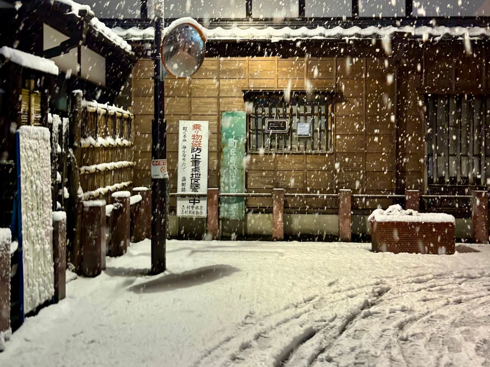 Snow falling on an old wooden street at night